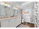 Stylish bathroom with dual sinks, a decorative mirror, and unique wallpaper design at 1625 S Ocean Blvd. # 1510, North Myrtle Beach, SC 29582