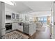 Well-lit kitchen with white cabinets, stainless steel appliances, and granite countertops overlooking dining area at 1625 S Ocean Blvd. # 1510, North Myrtle Beach, SC 29582
