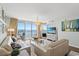Spacious living room with ocean view, neutral furniture, and a large flat-screen TV at 1625 S Ocean Blvd. # 1510, North Myrtle Beach, SC 29582