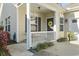 Welcoming front porch with a white railing, yellow wreath, and a charming entryway at 173 Knight Circle # 1, Pawleys Island, SC 29585