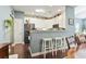 Bright kitchen featuring white cabinetry, modern appliances, and a cozy breakfast bar with three white stools at 173 Knight Circle # 1, Pawleys Island, SC 29585