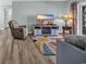 Comfortable living room with wood floors, stylish rug, and modern entertainment center and fireplace at 178 Salt Marsh Circle # 30D, Pawleys Island, SC 29585