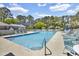 Sparkling pool with lounge chairs and umbrellas surrounded by mature trees at 178 Salt Marsh Circle # 30D, Pawleys Island, SC 29585