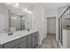 Bathroom with double vanity, gray cabinets, framed mirrors, shower and a walk in closet at 2191 Gooseberry Way, Longs, SC 29568