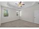 View of the spacious bedroom with tray ceiling, fan, carpet, and two windows at 2191 Gooseberry Way, Longs, SC 29568