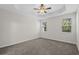 Spacious bedroom with neutral carpet, tray ceiling, ceiling fan, and two windows at 2191 Gooseberry Way, Longs, SC 29568