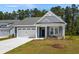 Charming single-story home with a two-car garage, a gray exterior, and landscaped front yard at 2191 Gooseberry Way, Longs, SC 29568