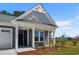 Inviting front porch with craftsman columns and beautiful landscaping at 2191 Gooseberry Way, Longs, SC 29568
