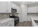 Modern kitchen featuring white cabinets, stainless steel oven, and stylish backsplash at 2191 Gooseberry Way, Longs, SC 29568