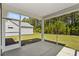 View of the outdoor screened in patio and backyard with trees in the background at 2191 Gooseberry Way, Longs, SC 29568
