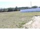 A grassy back lot is bordered by a white vinyl fence and thick woods at 2519 Southern Crest Dr., Loris, SC 29569