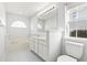 Bright bathroom featuring a dual sink vanity, soaking tub, tiled floor, and arched windows at 2633 Corn Pile Rd., Myrtle Beach, SC 29588