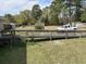 Backyard view with a wooden deck, a white pickup truck, gazebo and shed surrounded by green grass and mature trees at 301 Byrnes Circle, Johnsonville, SC 29555