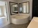Bathroom with jacuzzi tub, double mirrors, and tiled floor at 301 Byrnes Circle, Johnsonville, SC 29555