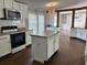 Bright kitchen featuring white cabinets, stainless steel appliances, and island with a view to the living area at 301 Byrnes Circle, Johnsonville, SC 29555