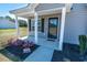 Inviting front porch with black door, white pillars, and stylish landscaping at 3016 Wise Rd., Conway, SC 29526
