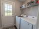 Bright laundry room with new washer and dryer, shelving, and a door to the outside at 3016 Wise Rd., Conway, SC 29526