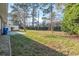 Green backyard featuring mature trees, lush grass, and a white picket fence, creating a peaceful setting at 3494 Cactus St. # 3494, Myrtle Beach, SC 29577