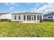This backyard features a spacious sunroom and a patio with green grass all around at 351 Firenze Loop, Myrtle Beach, SC 29579