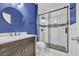 A stylish bathroom features a glass shower with a dark wood vanity and a round mirror at 351 Firenze Loop, Myrtle Beach, SC 29579