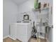 This laundry room features updated appliances and storage shelving above the washer and dryer at 351 Firenze Loop, Myrtle Beach, SC 29579
