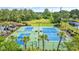 Aerial view of community tennis courts with bright blue surface and mature landscaping at 351 Firenze Loop, Myrtle Beach, SC 29579