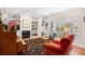 Cozy living room with fireplace, built-in shelving, piano, and a comfortable red armchair at 381 Da Gullah Way # 8 B, Pawleys Island, SC 29585