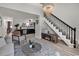 Cozy living room with light wood flooring, staircase, and view to the kitchen and dining space at 400 Cambridge Circle # L-7, Murrells Inlet, SC 29576
