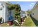 Side yard featuring flowerbeds, wrought iron details, an archway, and well-maintained lawn at 413 Chesterfield Ct., Myrtle Beach, SC 29577