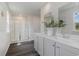 Bright bathroom featuring double sinks, quartz countertop, a glass-enclosed shower, and vinyl flooring at 414 Acosta Circle, Conway, SC 29527
