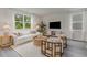 Bright living room featuring a white sofa, decorative chairs, a large window, and stylish decor at 414 Acosta Circle, Conway, SC 29527