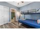 Bunk bedroom with attached bathroom featuring laminate floors and gray-blue walls at 4141 Hibiscus Dr. # 201, Little River, SC 29566