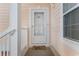 Inviting covered front door entry with peach-colored siding and brick at 4141 Hibiscus Dr. # 201, Little River, SC 29566
