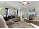 Bright living room featuring a beige sectional, ceiling fan, and large TV with fireplace at 4141 Hibiscus Dr. # 201, Little River, SC 29566