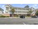 Three-story condo building featuring covered balconies, exterior stairs, and parking at 4155 Hibiscus Dr. # 204, Little River, SC 29566