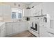 Bright white kitchen featuring white appliances and arched window at 4155 Hibiscus Dr. # 204, Little River, SC 29566