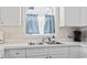 Bright kitchen with double bowl sink and white cabinets at 4155 Hibiscus Dr. # 204, Little River, SC 29566