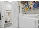 Convenient laundry area with washer, dryer, and shelving for storage; a bathroom is also connected at 4155 Hibiscus Dr. # 204, Little River, SC 29566