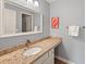 Bathroom featuring a granite countertop, decorative mirror, and light blue walls at 45 Pinehurst Ln. # 2G, Pawleys Island, SC 29585