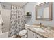 Bathroom featuring tile floors, granite countertop, decorative mirror, and shower with seashell curtain at 45 Pinehurst Ln. # 2G, Pawleys Island, SC 29585