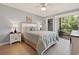 Bright main bedroom with ceiling fan, lamps on the bedside tables, and access to a private balcony at 45 Pinehurst Ln. # 2G, Pawleys Island, SC 29585