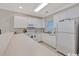 Bright kitchen featuring white cabinetry, countertops, tile flooring, and modern appliances at 4865 Magnolia Pointe Ln. # 204, Myrtle Beach, SC 29577