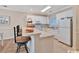 Bright kitchen with white cabinets, appliances, tile floor, and breakfast bar seating at 4865 Magnolia Pointe Ln. # 204, Myrtle Beach, SC 29577