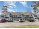 Three-story condo building featuring gray siding and multiple cars in the parking lot in front at 500 Fairway Village Dr. # 5D, Myrtle Beach, SC 29588