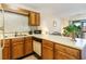 Galley kitchen boasts wood cabinets, white counter tops, and a mosaic backsplash with appliances included at 500 Fairway Village Dr. # 5D, Myrtle Beach, SC 29588