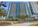 High-rise resort with balconies overlooking lush landscaping and palm trees for a luxurious stay at 504 N Ocean Blvd. # 411, Myrtle Beach, SC 29577