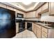 Modern kitchen featuring wood cabinets, granite countertops, and black appliances at 504 N Ocean Blvd. # 411, Myrtle Beach, SC 29577