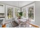 Bright dining area with large windows, a rustic table, and seating for Gathering meals at 53 Hope Ln., Pawleys Island, SC 29585