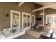 Inviting covered porch with swing sofa, ceiling fan, and outdoor dining area at 53 Hope Ln., Pawleys Island, SC 29585