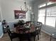 Bright dining room featuring a chandelier, large window, and a round wooden table with chairs at 59 Willowbend Dr., Murrells Inlet, SC 29576